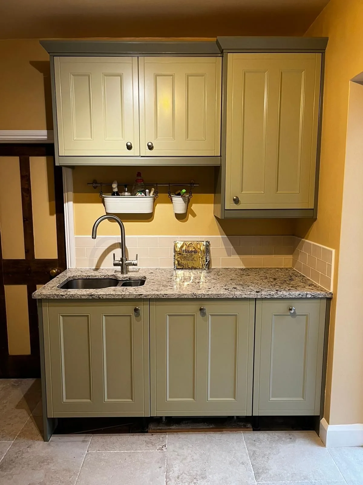 Sage green kitchen with granite worktop and tiled splashback