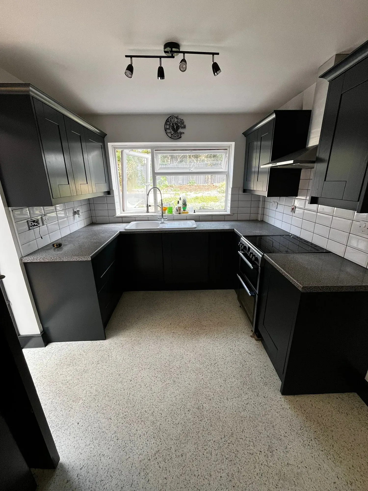 Dark grey U shaped kitchen with a speckled worktop