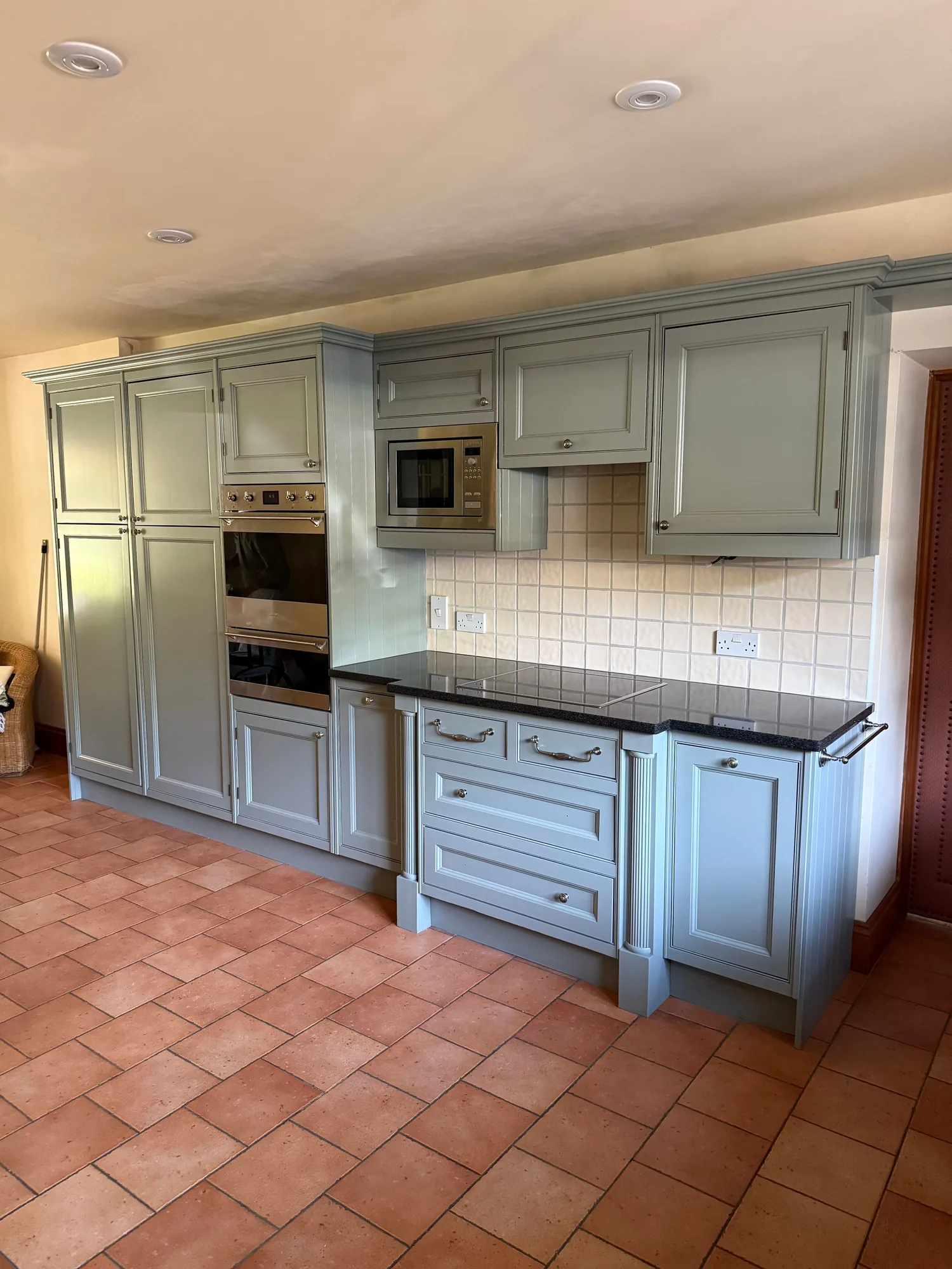Sage green traditional kitchen with a terracotta tiled floor